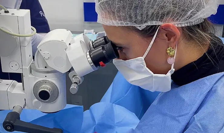 Veterinária do Santa Vida examinando um paciente ao microscópio